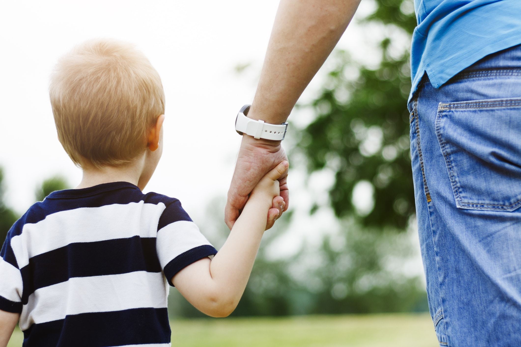 Child walking hand in hand with parent