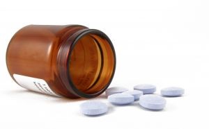bottle of pills spilled over symbolizing opioid addiction