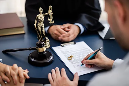 Young couple consulting with a lawyer in court to sign a divorce agreement document.