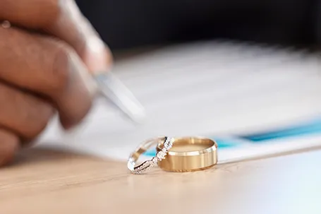 Divorce, rings and signature on paperwork for a lawyer.