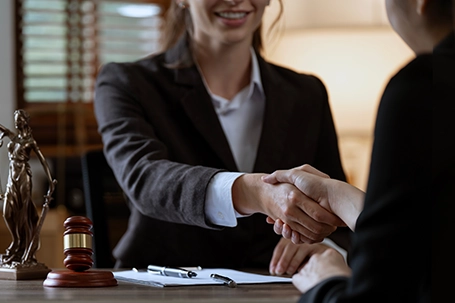 Businesswoman shaking hands to make a deal with her partner lawyers or attorneys discussing a contract agreement.