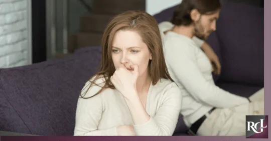 A woman turning her back on her husband, feeling upset after an argument.