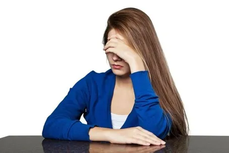 An image of a girl feeling upset with her hand on her forehead.