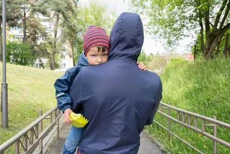 An image of a man carrying a child.