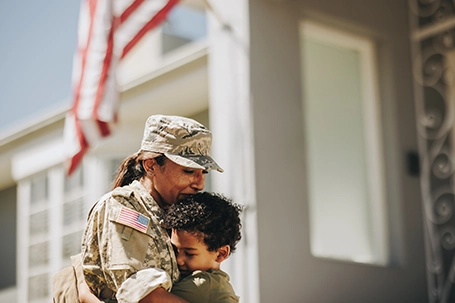 Emotional military mom embracing her son after returning home from the army.