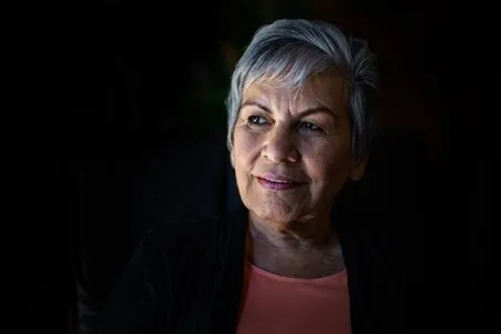 An image of a woman with short white hair smiling.