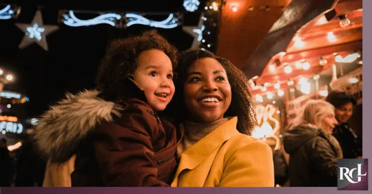 An image of a mother and her daughter looking up and smiling.