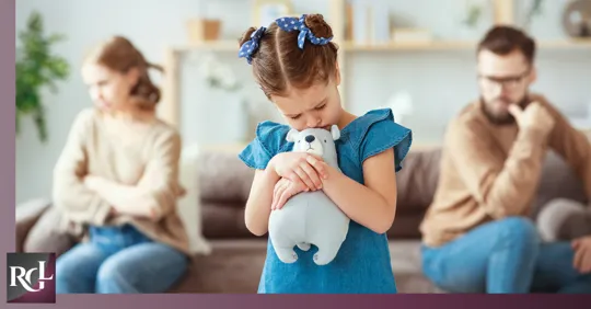 A cute little girl hugs her stuffed toys while her parents appear to be arguing in the background.