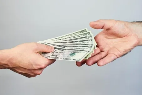 An image of someone handing money to another person.