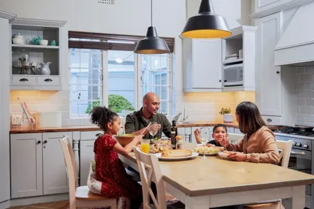 A happy family is eating together in the dining area.
