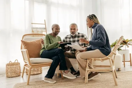 Three people are sitting and discussing something.