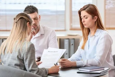 Three people reviewing and discussing the divorce papers they have read