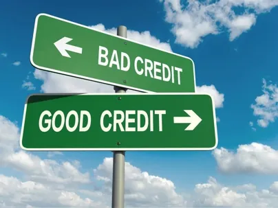 A “BAD CREDIT” and “GOOD CREDIT” sign under a blue sky.