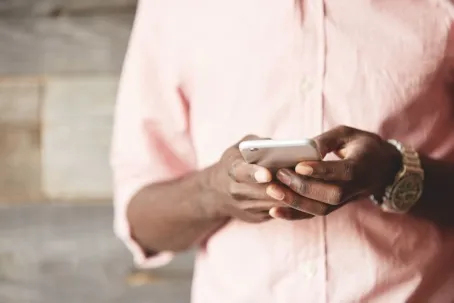 A man holding his phone while texting.